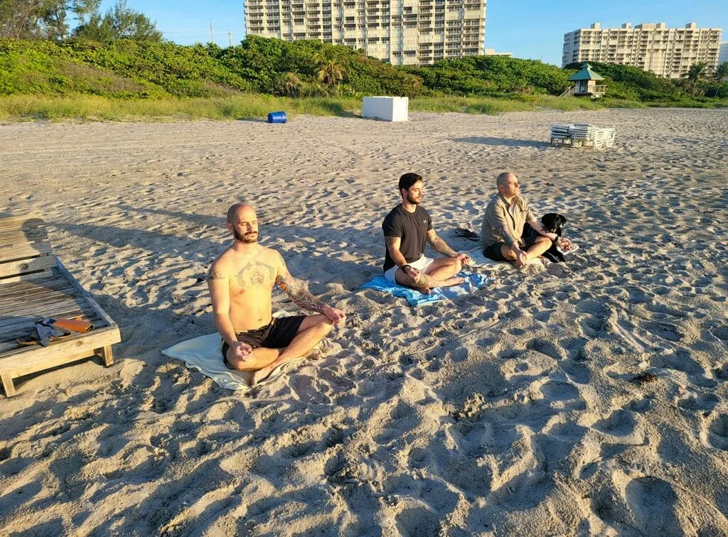 Veterans meditating on the beach at sunrise